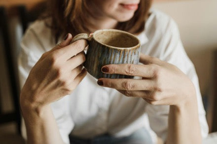 A woman holding a cup of mushroom cocoa
