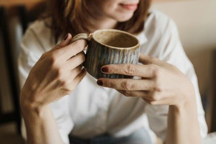 A woman holding a cup of mushroom cocoa